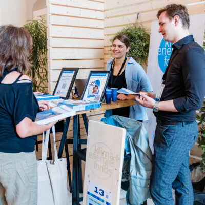 A photography showing three people standing around a booth talking